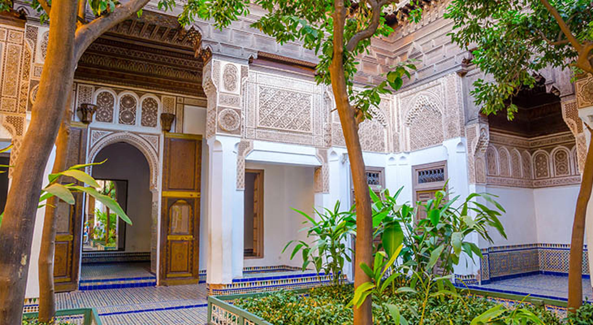 Bahia paleis Binnenplaats van een Marokkaanse riad met mozaïektegels, houtsnijwerk en groene tuin.