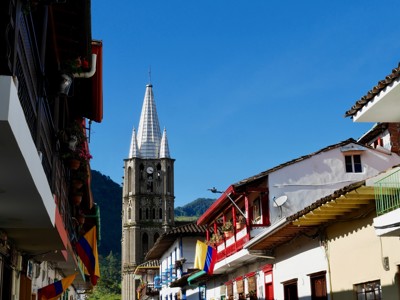 Kerk met hoge toren in kleurrijke straat in Colombia, Route Colombia dag 11.