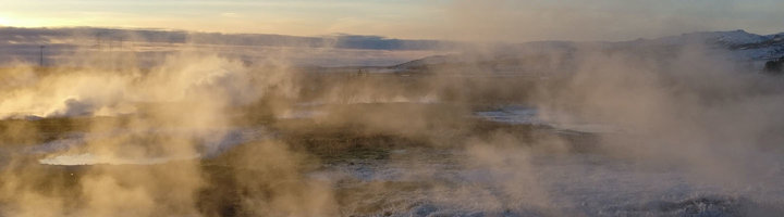 Stoomwolken boven het geothermische gebied van Geysir in IJsland bij zonsopkomst.