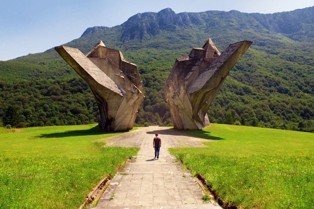Monument Sutjeska bij Tjentište in Bosnië en Herzegovina, met bergen en groen landschap op de achtergrond.