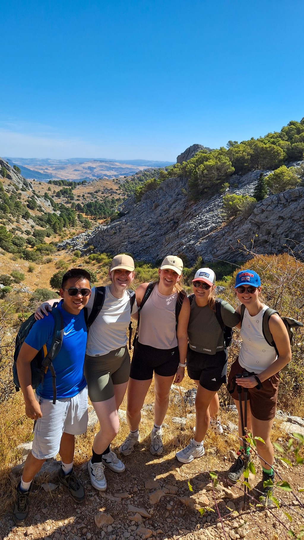 Groep wandelaars tijdens 22-35ers reis door Andalusië met uitzicht over rotsachtige heuvels.