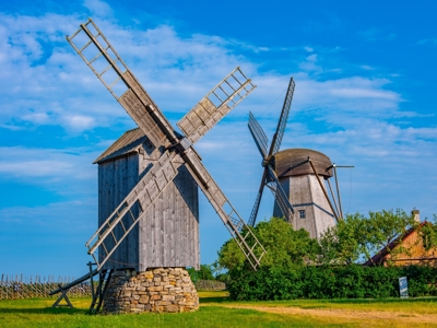 Twee houten windmolens in het open landschap tijdens de Route Baltische Staten.