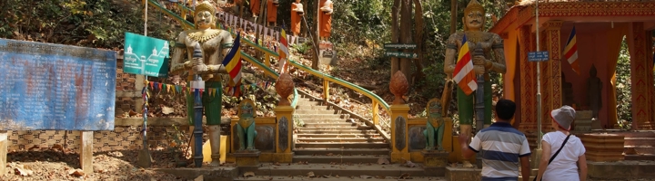 Trap naar een boeddhistische tempel met monnikenbeelden en wachters, Kratie, Cambodja.