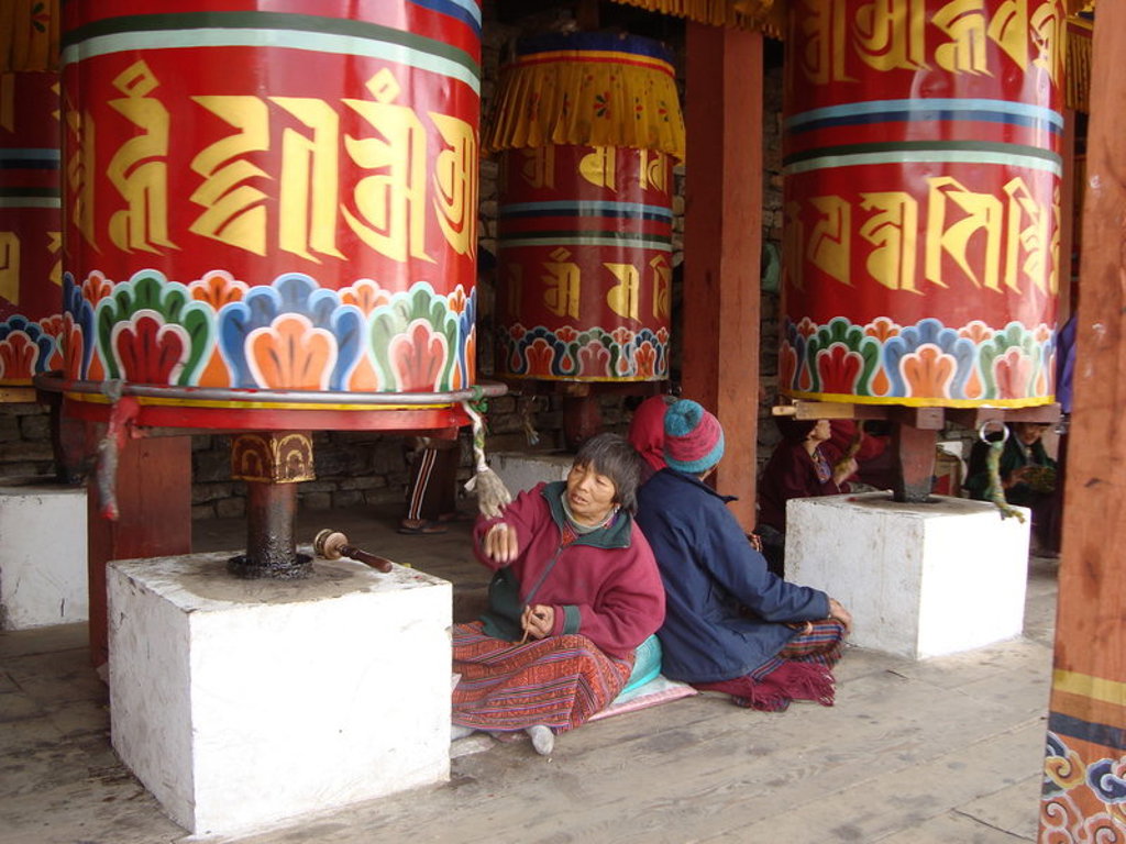 Reizigers draaien kleurrijke gebedsmolens in een boeddhistisch klooster in Sikkim of Bhutan.