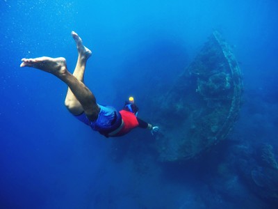 Snorkelaar zwemt boven een scheepswrak in de zee bij Bali.