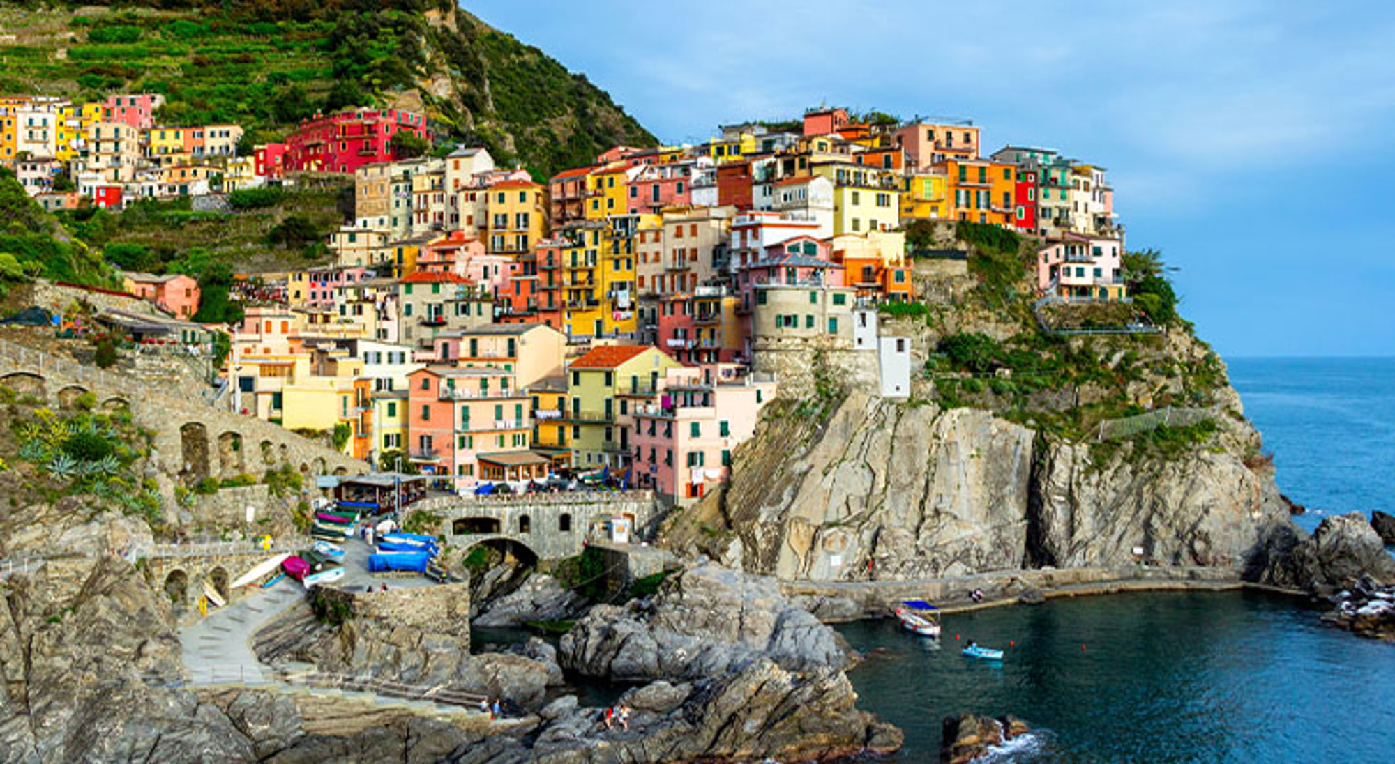 Kleurrijke huizen van Manarola in Cinque Terre aan de rotskust, met haven en zee.