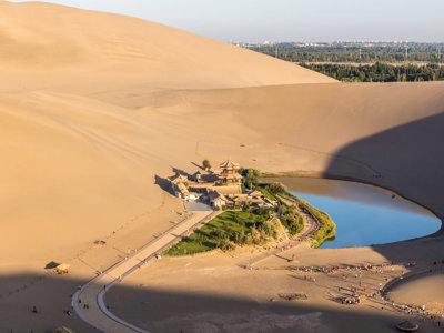 Crescent Lake-oase met tempel tussen hoge zandduinen bij Dunhuang, Zijderoute met de trein.
