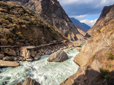 Rivierkolk in de Tiger Leaping Gorge met wandelpad langs steile rotswanden, Route China 32 dagen.
