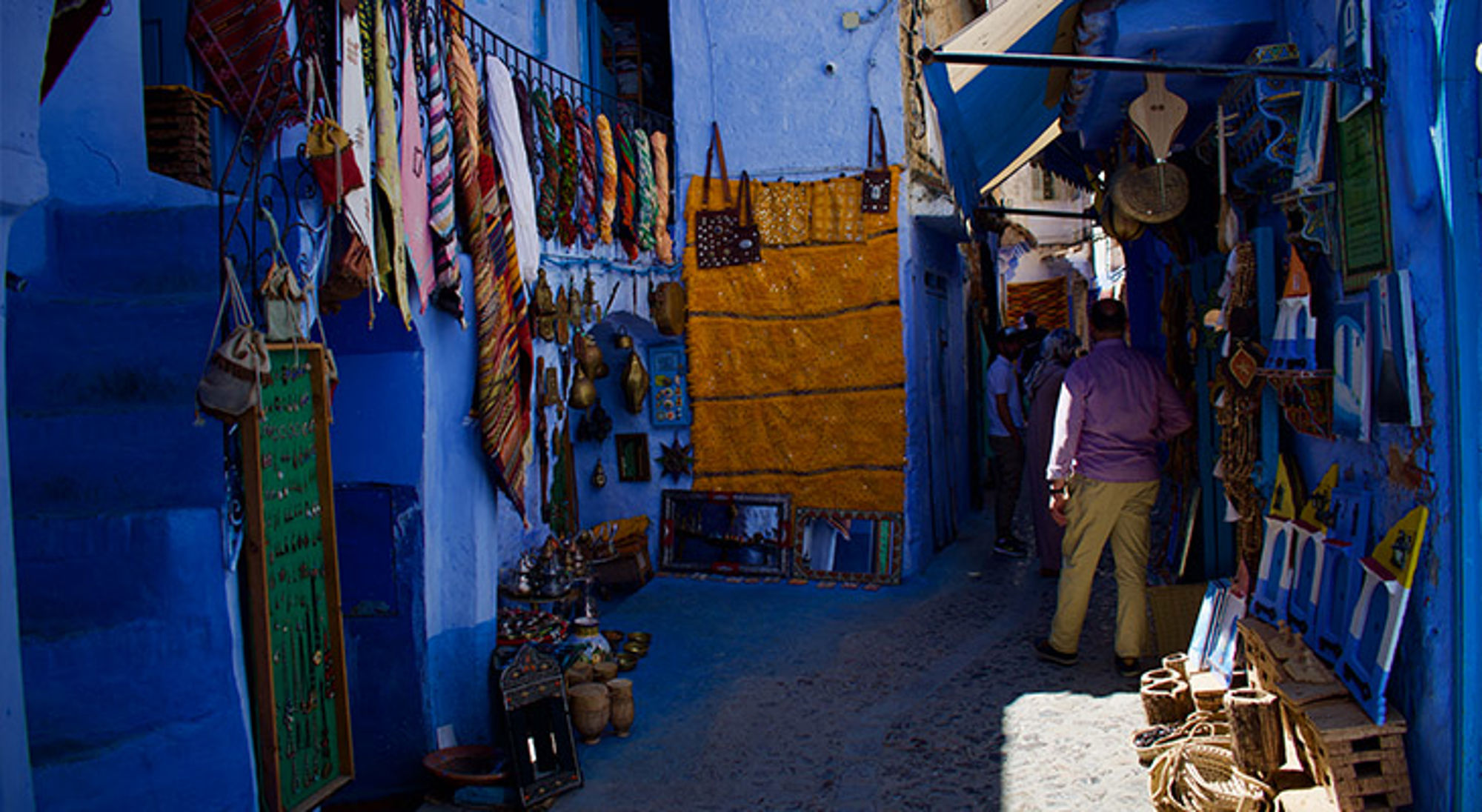Chefchaouen Smalle blauwe steeg met souvenirwinkels en wandkleden in Chefchaouen, Marokko.