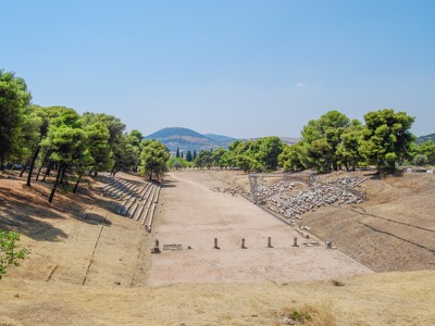 Oud stadion van het Panathenaïsche Stadion in Athene, met stenen tribunes en pijnbomen.