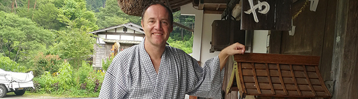 Richard in Japanse yukata bij een traditioneel gebouw, tijdens een reis.