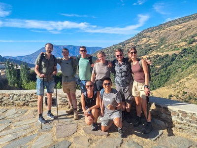Groep 22-35ers wandelaars poseert met berglandschap op de achtergrond tijdens rondreis in Andalusië, Spanje.