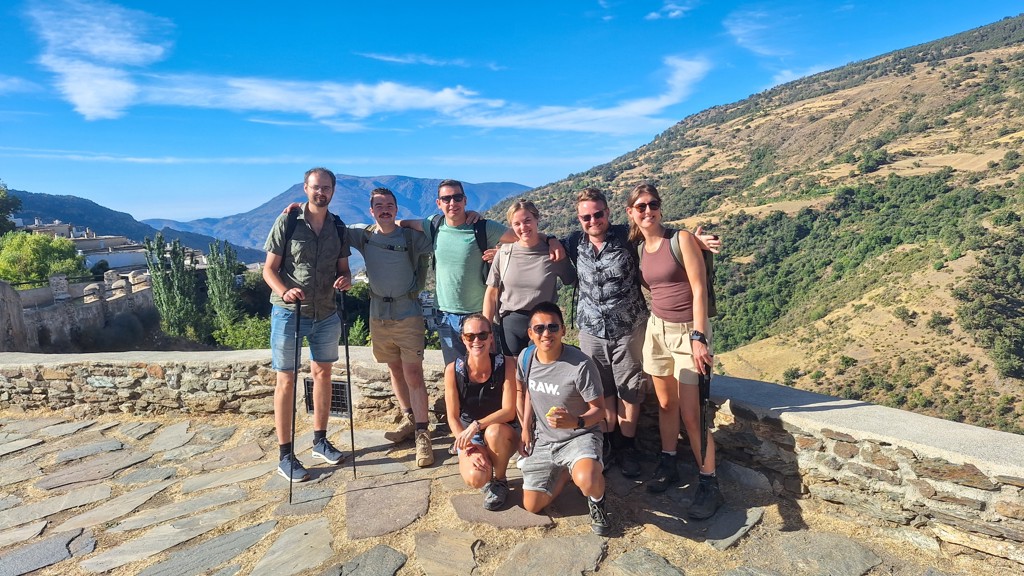 Groep 22-35ers wandelaars poseert met berglandschap op de achtergrond tijdens rondreis in Andalusië, Spanje.