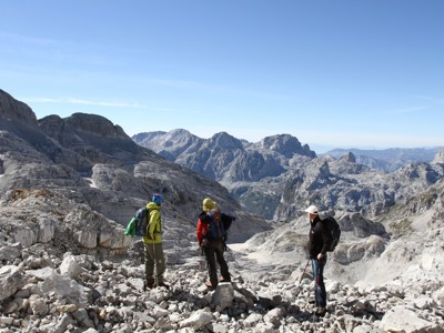Wandelaars met rugzakken in rotsachtig berglandschap tijdens de Route Balkan wandelrondreis.