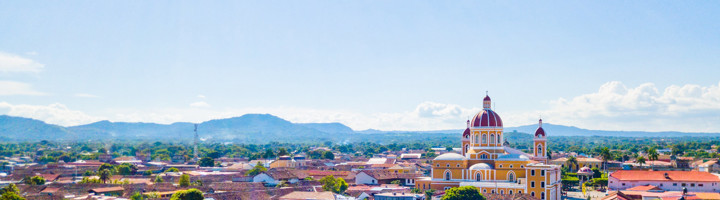 Uitzicht over Granada in Nicaragua met de kleurrijke kathedraal en bergen op de achtergrond.