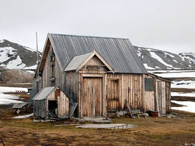 Houten hut Camp Mansfield in een besneeuwd berglandschap.