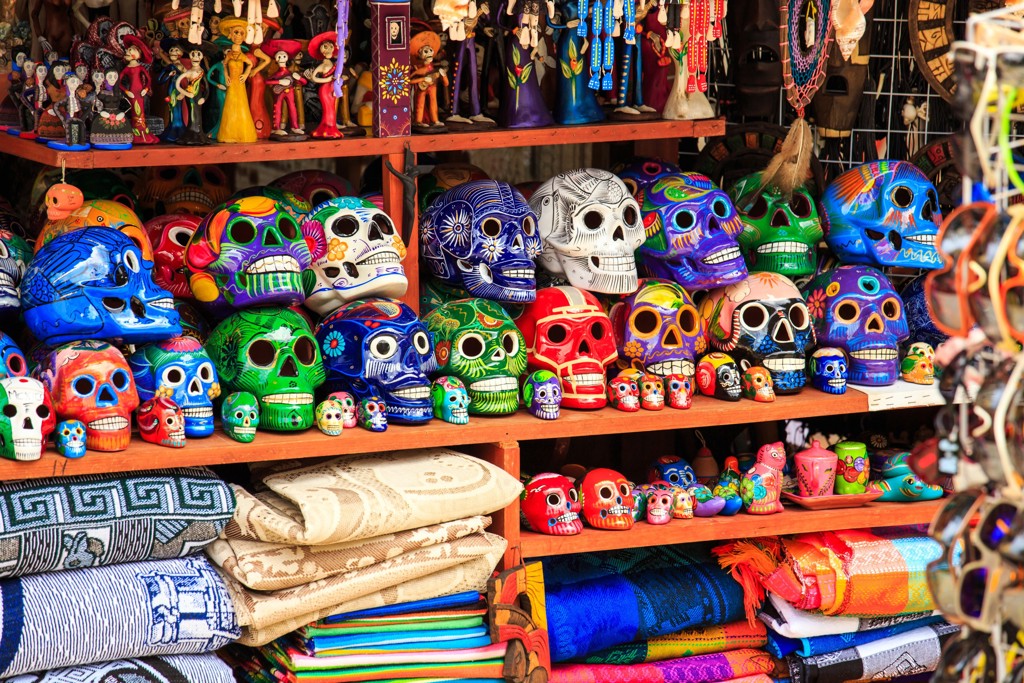 Kleurrijke Mexicaanse calavera-schedels en souvenirs op een marktstand tijdens een groepsrondreis Mexico.