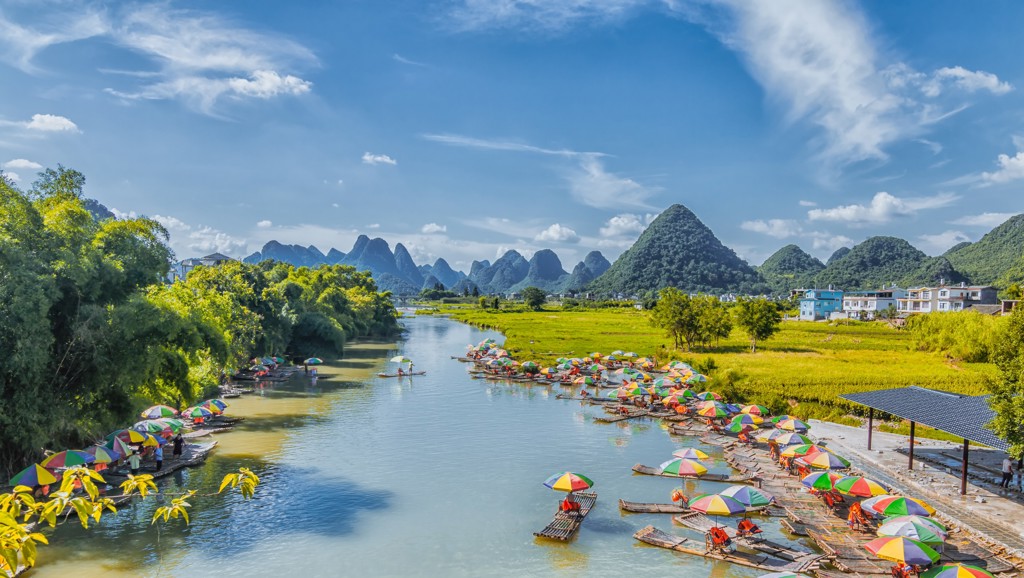 Bamboevlotten met kleurrijke parasols op de rivier bij karstbergen in Guilin, China.