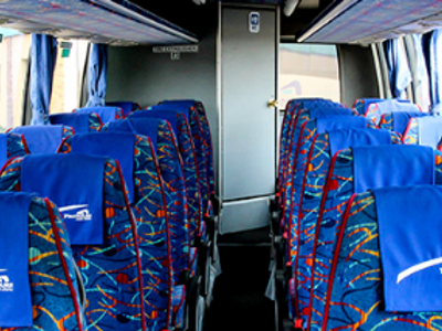 Interieur van een touringcar met blauwe stoelen voor vervoer tijdens rondreizen in Zuid-Afrika.