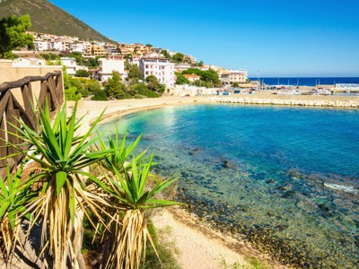Kustplaats aan zee op Sardinië met strand, haven en helderblauw water tijdens de 8-daagse wandelvakantie.