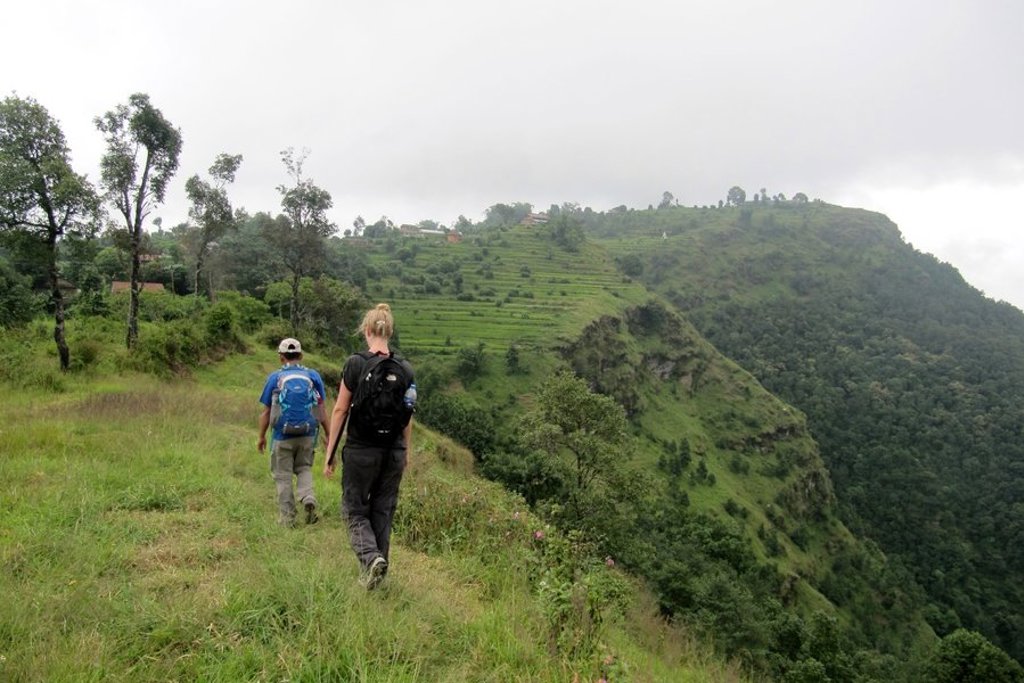 Mistige heuvels met silhouetten van bomen bij zonsopkomst tijdens een familiereis Nepal.