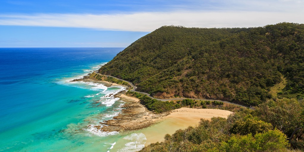 Kustweg langs turquoise zee en zandstrand bij Great Ocean Road, Australië.