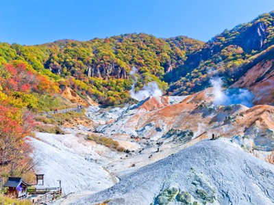 Stomende zwavelbronnen en kleurrijke bergen in Hell Valley (Jigokudani) bij Noboribetsu, Japan.