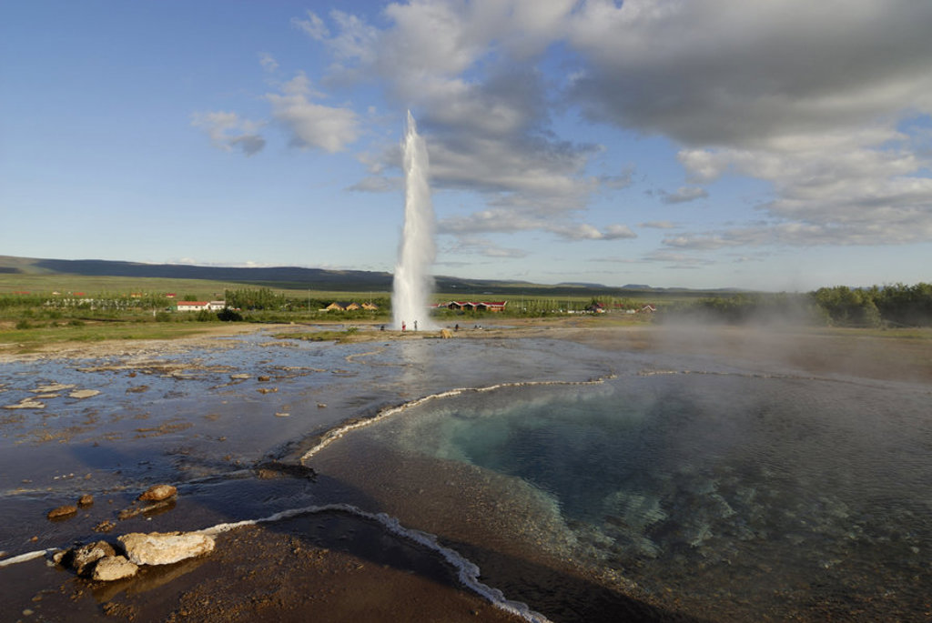 Geysir die hoog de lucht in spuit bij een warmwaterbron in IJsland tijdens een groepsrondreis.
