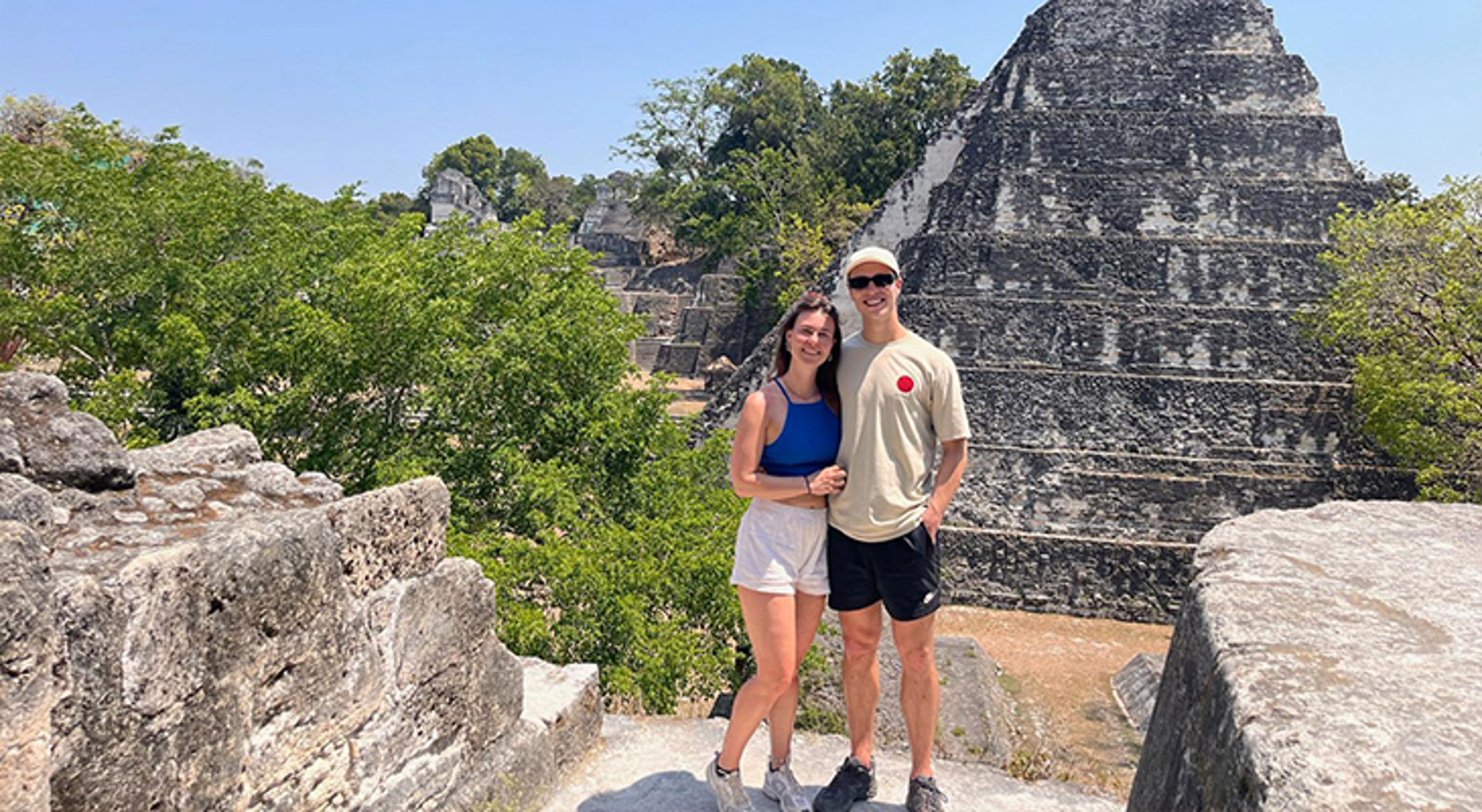 Céline in Guatemala Koppel poseert bij een Mayatempel tussen de jungle, met piramide op de achtergrond.