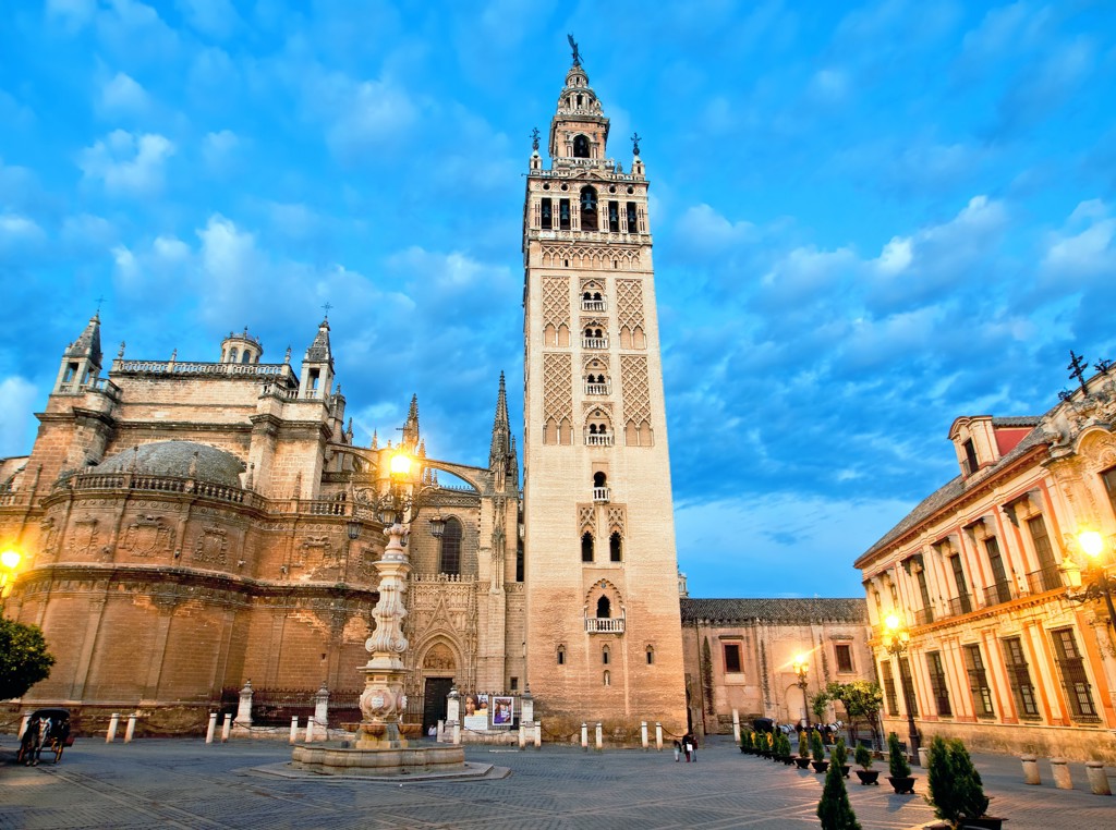Giralda-toren en de kathedraal van Sevilla bij schemering, hoogtepunten van een groepsrondreis door Andalusië.