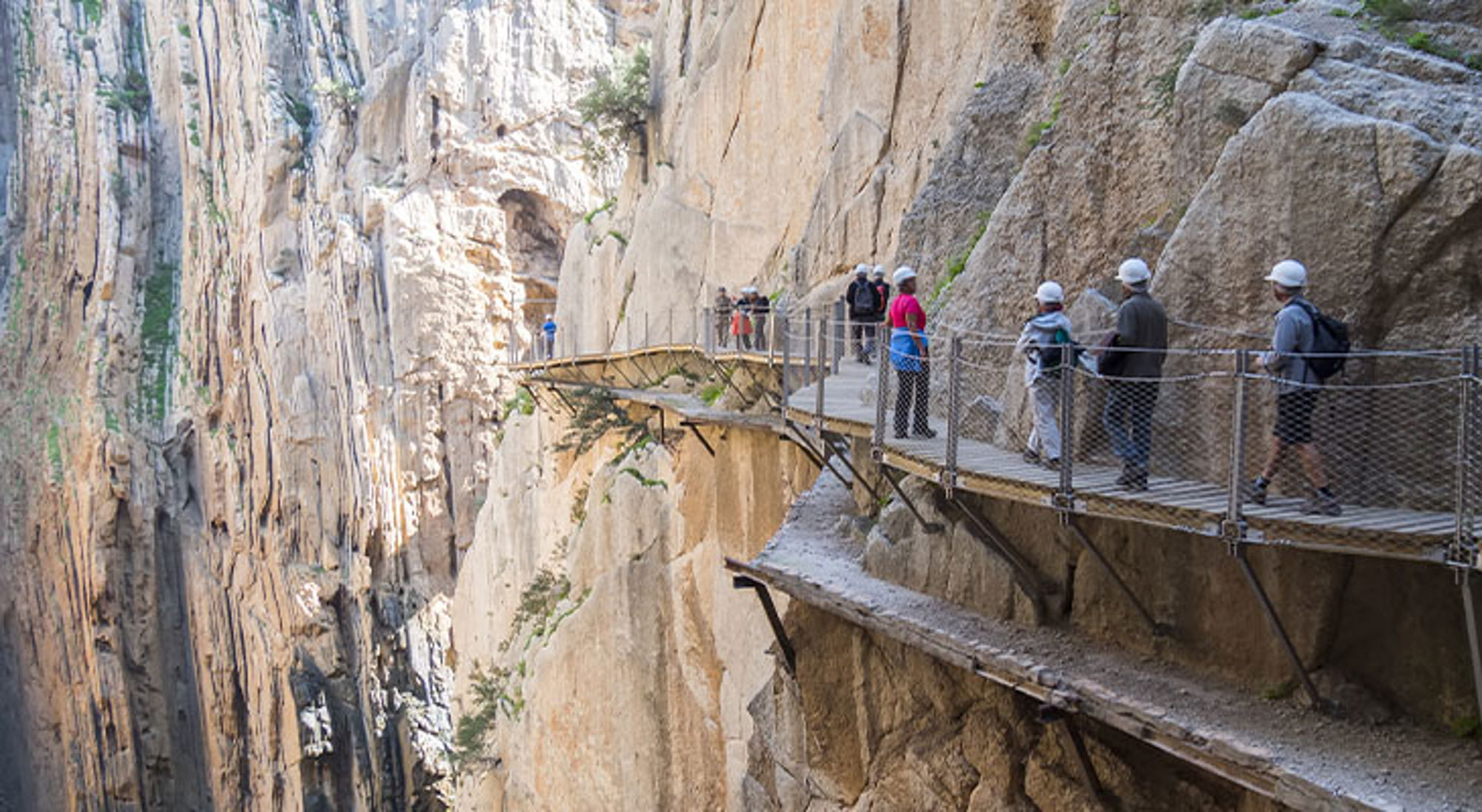 Caminito del Rey Spanje Wandelaars op de Caminito del Rey, een hangend wandelpad langs steile rotswanden in een kloof.