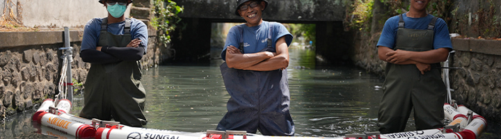 Team plaatst afvalbarrière van Sawadee en Sungai Watch in een kanaal op Bali.