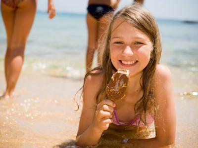 Meisje geniet van een ijsje op het strand tijdens de Andalusië familiereis van 9 dagen.