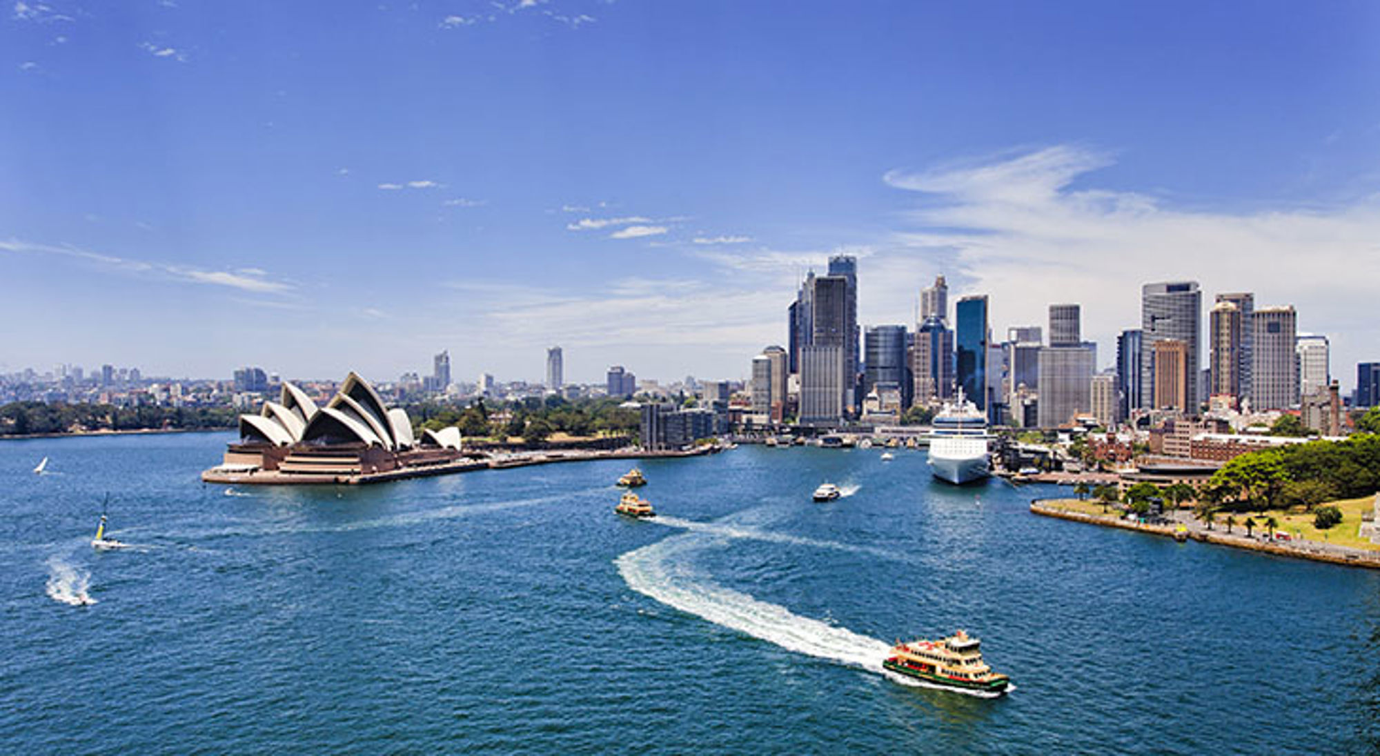 Sydney Harbour met het Sydney Opera House, skyline en veerboten op het water.