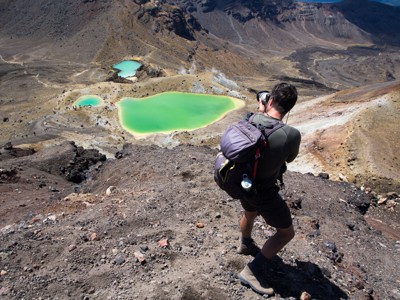 Wandelaar fotografeert felgroene kratermeren in het vulkanische Tongariro National Park, Nieuw-Zeeland.