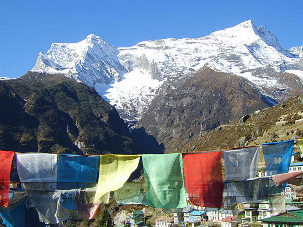 Gebedsvlaggen met besneeuwde Himalaya-bergtoppen tijdens groepsrondreis Nepal Everest.