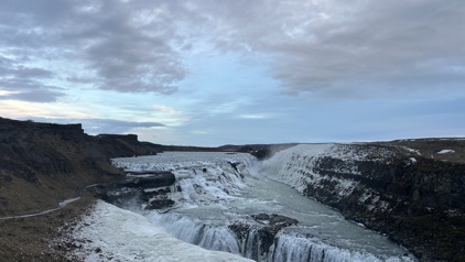 Bevroren waterval Gullfoss in winterse landschap van IJsland onder bewolkte lucht.