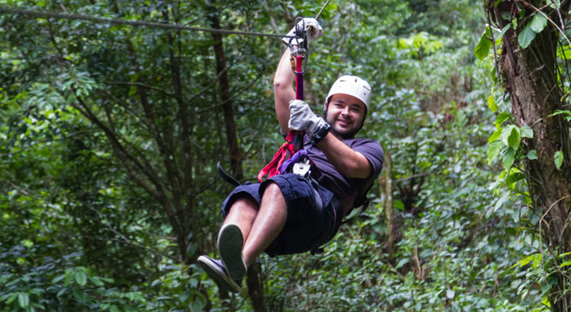 Zipline Monteverde Man tokkelt aan een zipline door het regenwoud in Costa Rica.