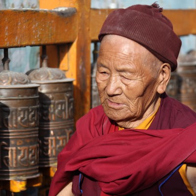 Boeddhistische monnik bij gebedsmolens tijdens de groepsrondreis Nepal Everest.
