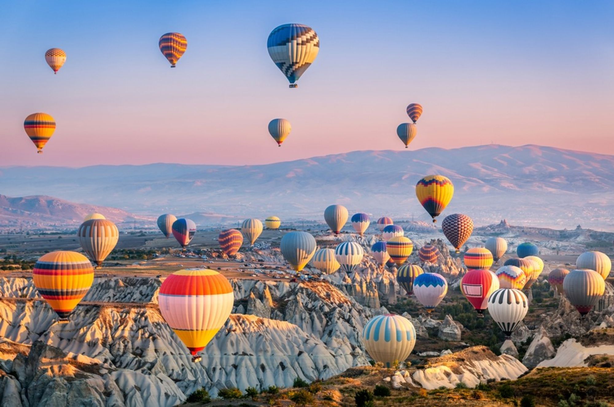 Heteluchtballonnen boven de rotsformaties van Cappadocië in Turkije bij zonsopgang.