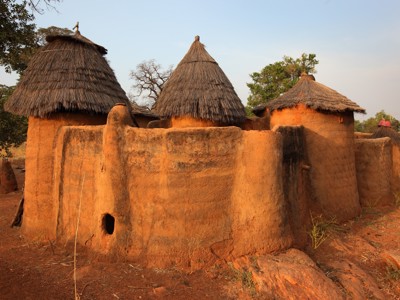 Traditionele lemen huizen met rieten daken langs de reisroute door Ghana, Togo en Benin.