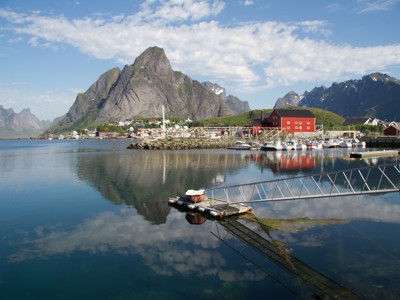 Haven met rode vissershuisjes en bergen in de Lofoten, Noorwegen, tijdens zeilreis met de Antigua.