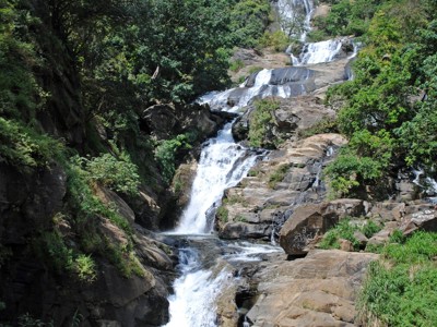 Waterval die in meerdere treden langs rotsen door een groene bergkloof stroomt in Sri Lanka.