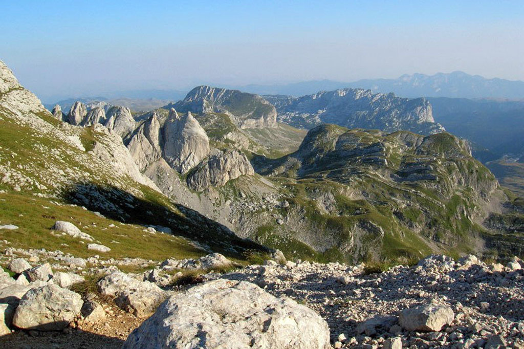 Panorama van rotsachtige bergtoppen en groene hellingen tijdens de groepsrondreis Balkan.
