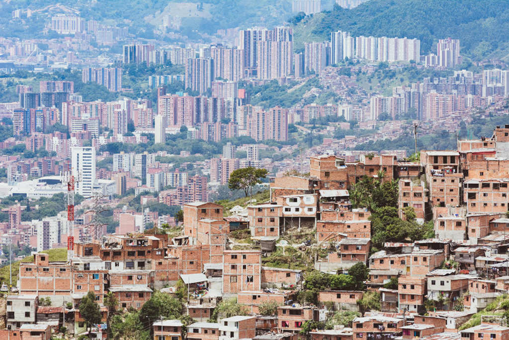Uitzicht over Medellín in Colombia met huizen op een heuvel en moderne hoogbouw op de achtergrond.