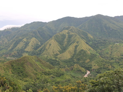 Groene bergketen met beboste heuvels en rivierdal op Sulawesi tijdens de rondreis Kalimantan, Sulawesi & Molukken.