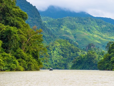 Boot op rivier tussen groene, mistige bergen tijdens de Route China & Vietnam (20 dagen).