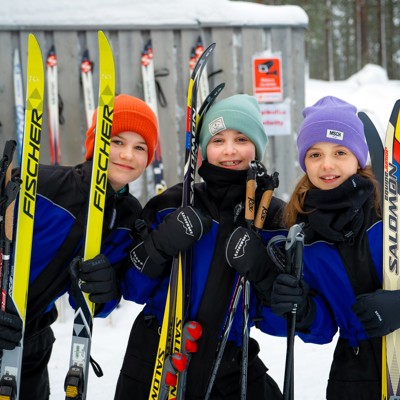 Kinderen met langlaufski’s en skistokken in de sneeuw tijdens Familiereis Lapland Winter.