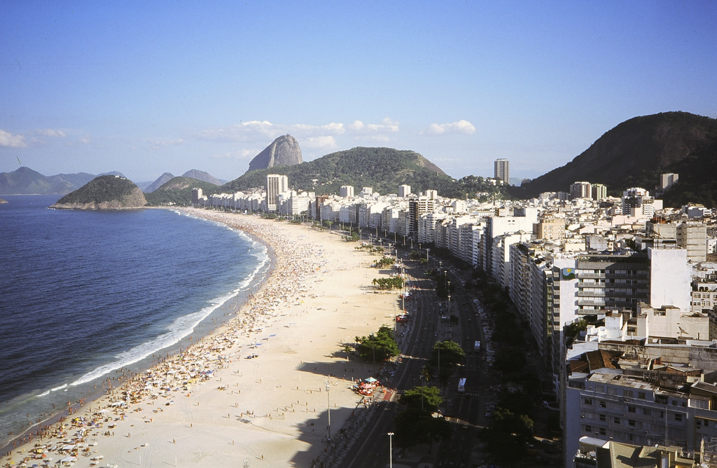 Uitzicht op Copacabana in Rio de Janeiro met strand, boulevard en Suikerbroodberg op de achtergrond.