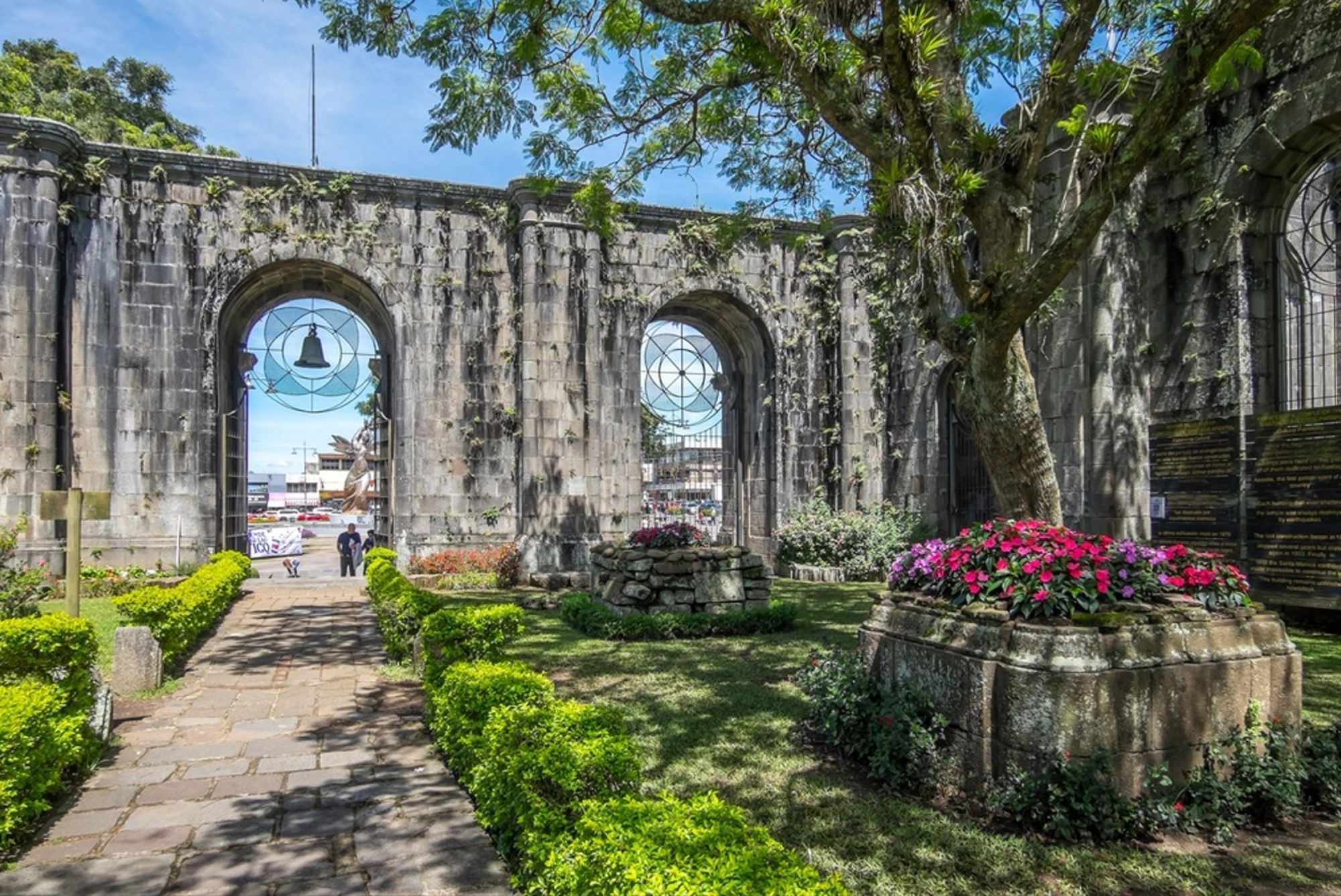 Ruïnes van de kathedraal van Cartago in Costa Rica, met bogen, klokken en bloeiende tuin.